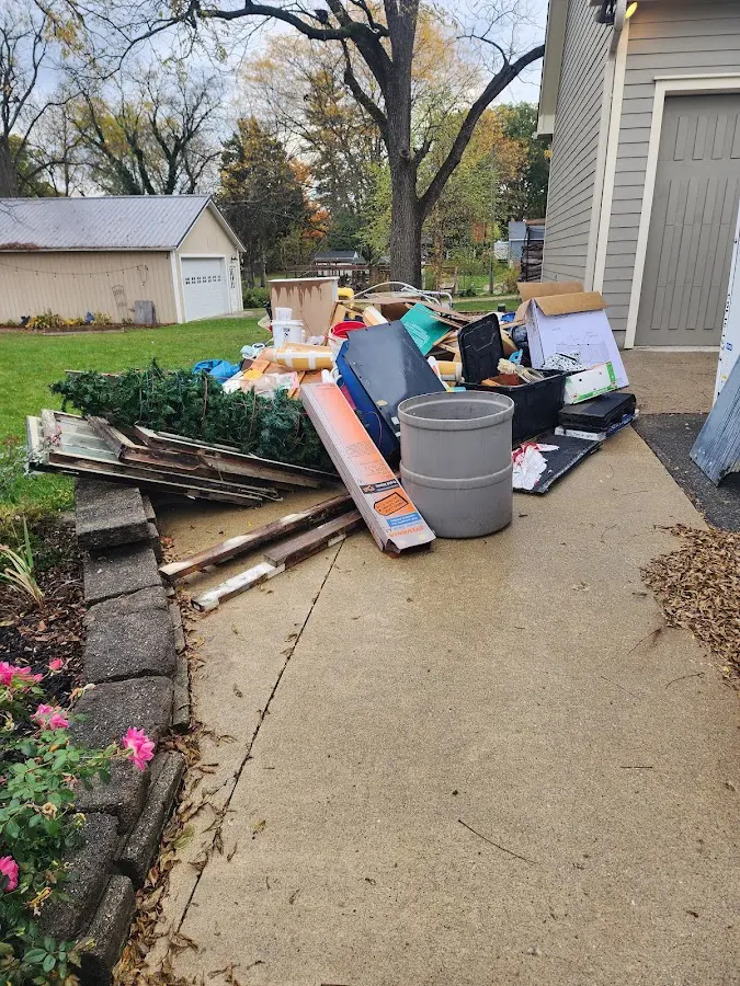 Dumpster being loaded with debris for Roofing Dumpster Rental in West Bend